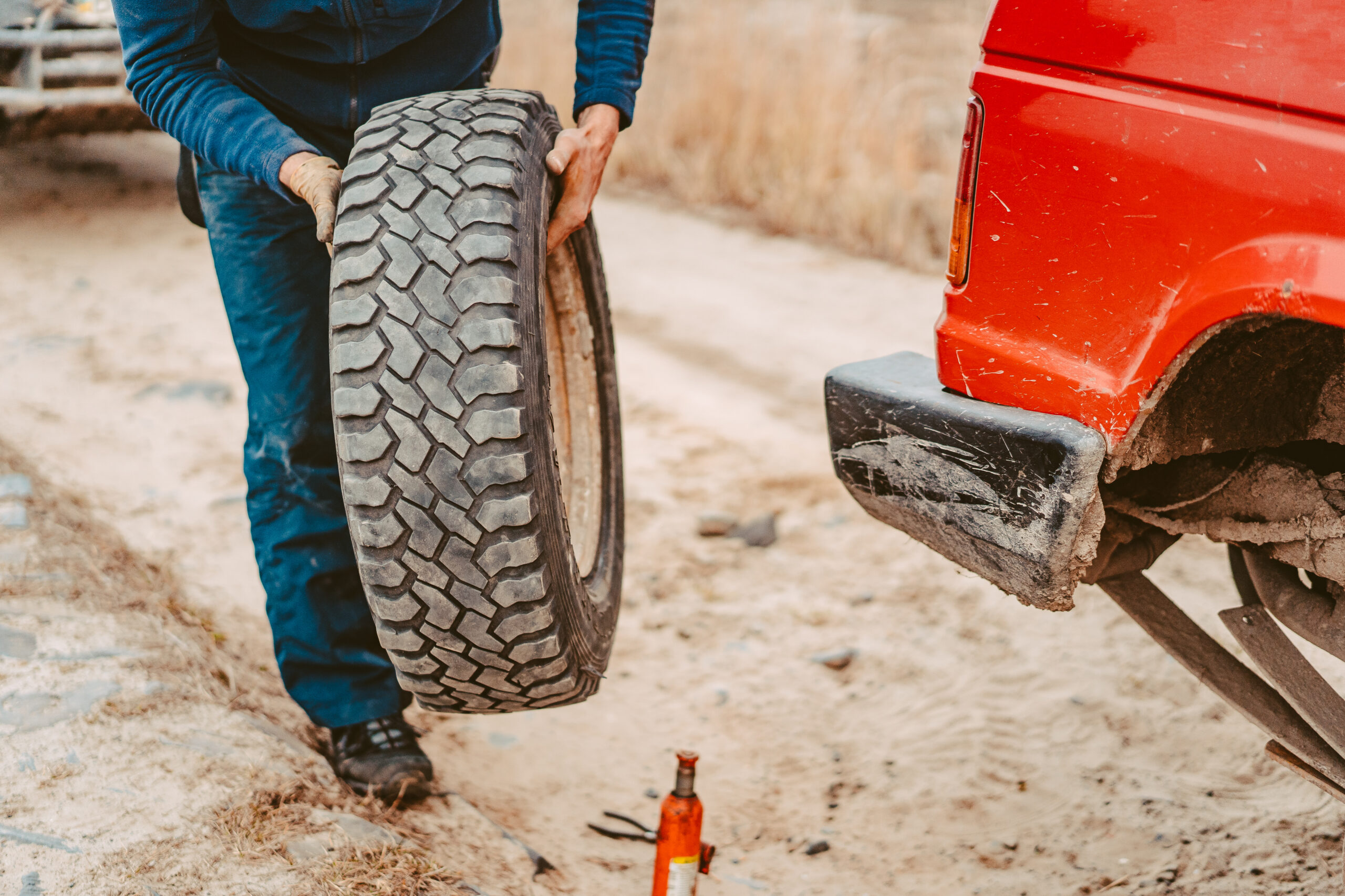 Man change the wheel manually on a 4x4 off road truck on the road